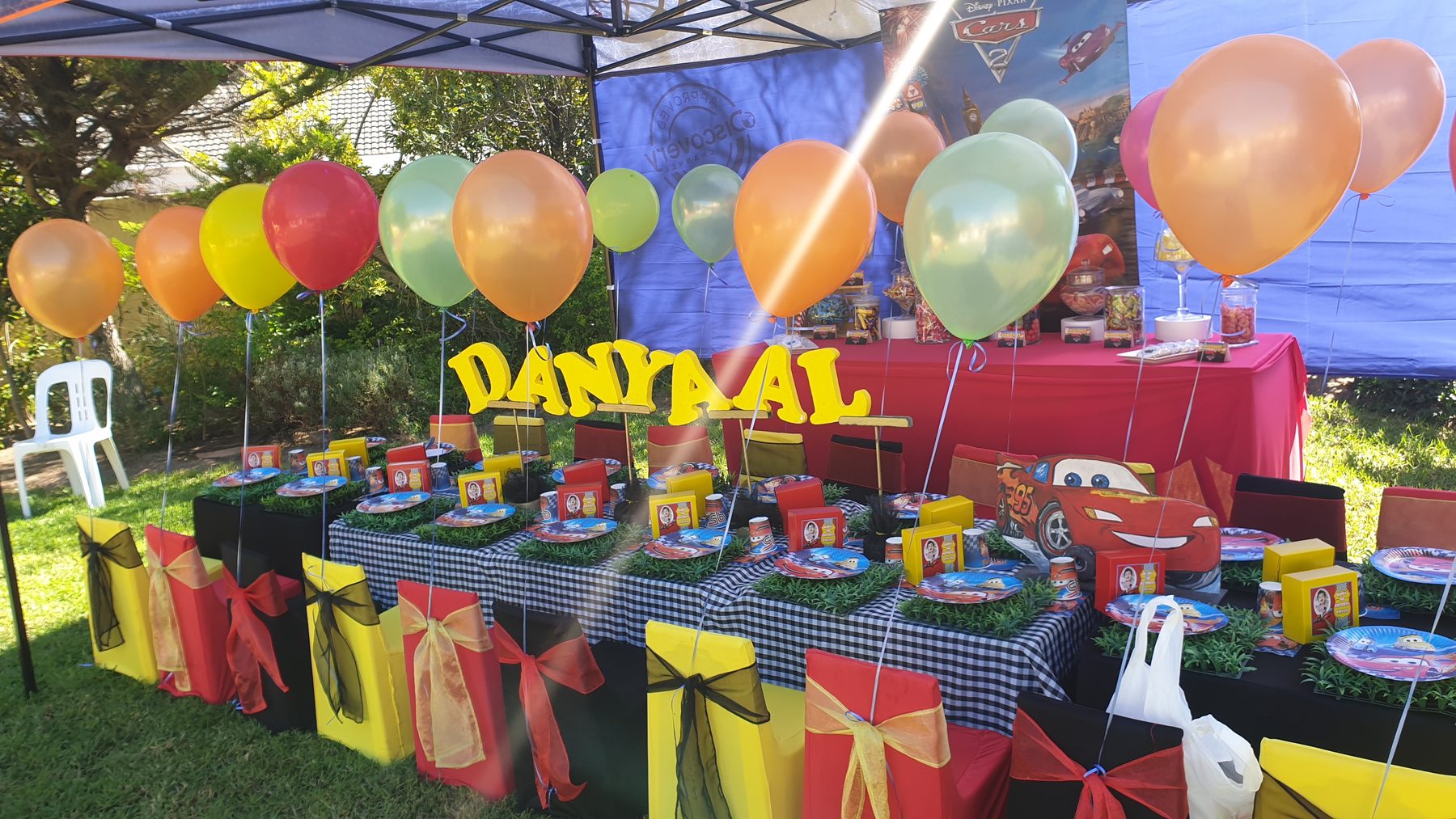 Colourful outdoor unisex party table with balloons
